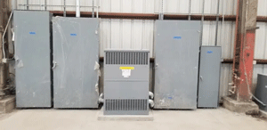 Gray electrical equipment lined up in a room.