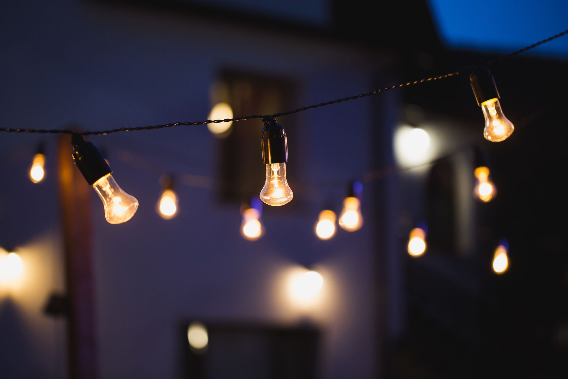 String of illuminated string lights against a blurred night backdrop.