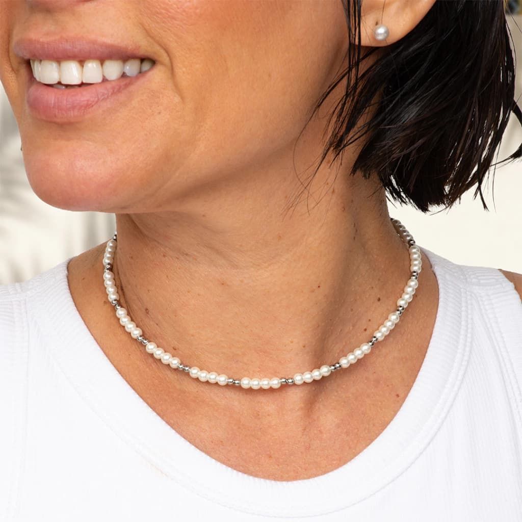 Collar y lata redonda con diseño de corazón. El collar lleva perlas y cuentas de plata.