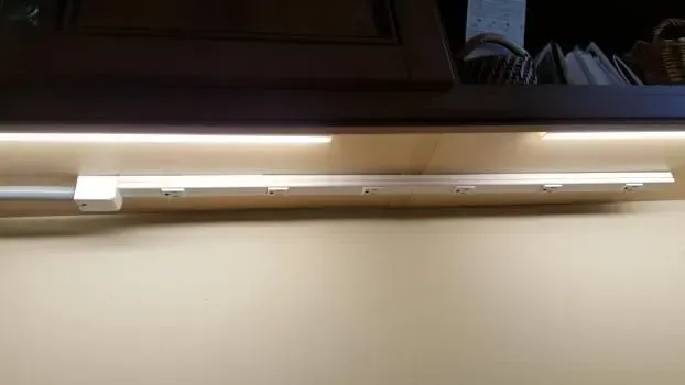 LED strip light fixture installed under a dark cabinet.