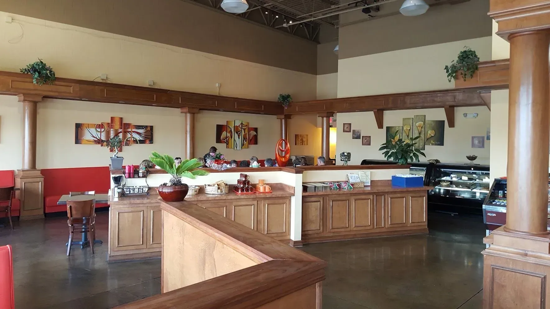 Interior of a restaurant with wooden counters, tables, and art.