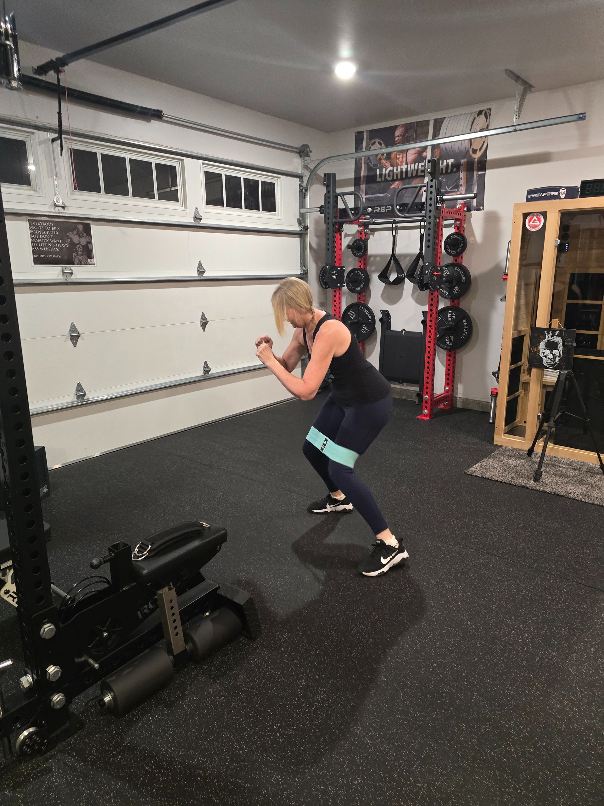 Man exercising with dumbbell, instructor watching in gym; orange accents, 