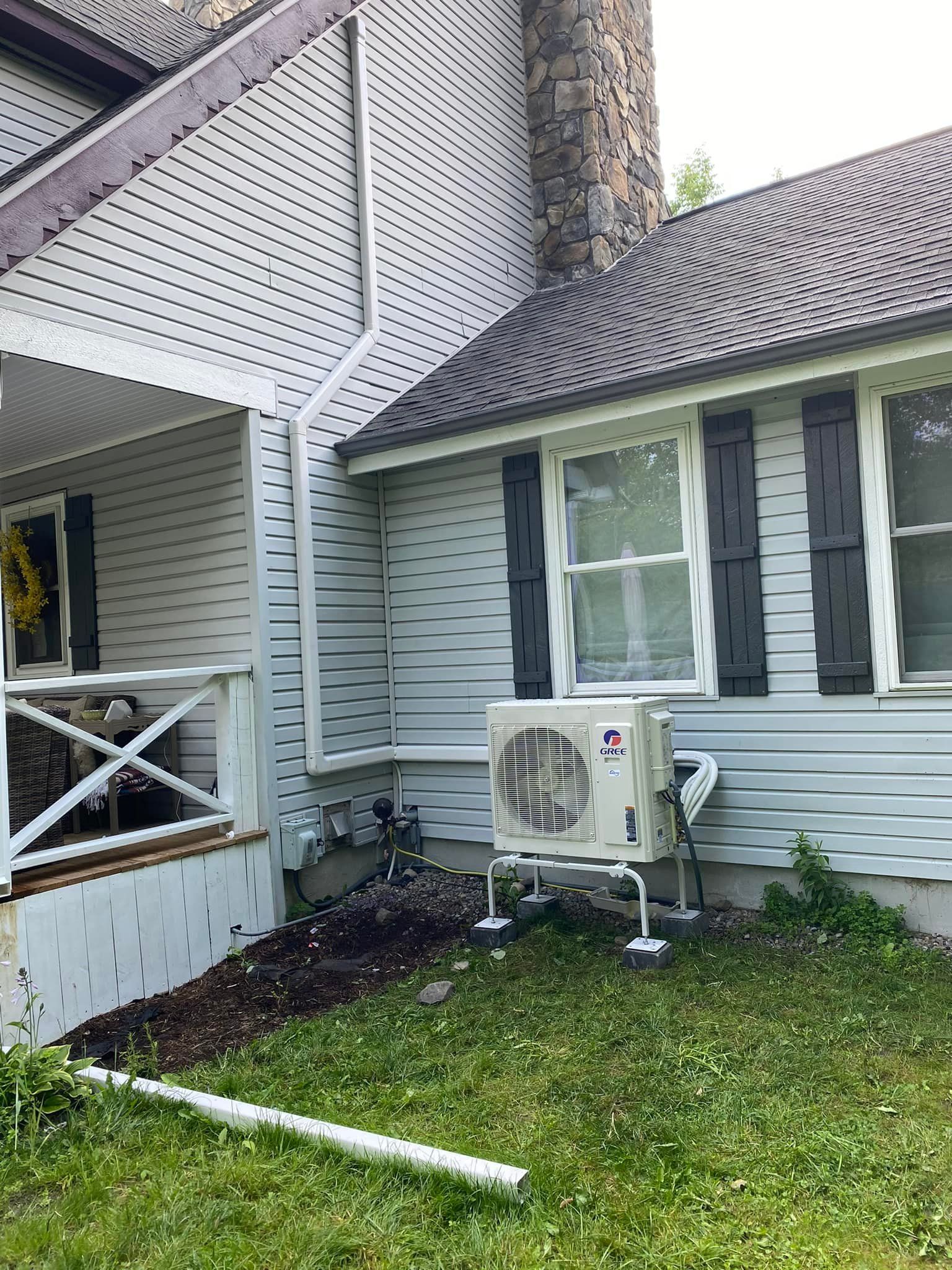 A white house with a large air conditioner on the side of it.