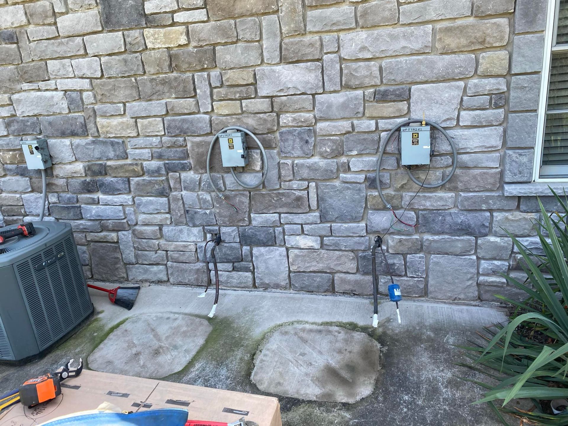 A brick wall with three electrical outlets on it