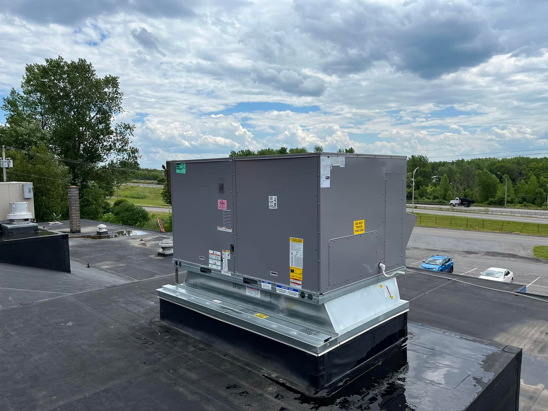 A large air conditioner is sitting on top of a roof.