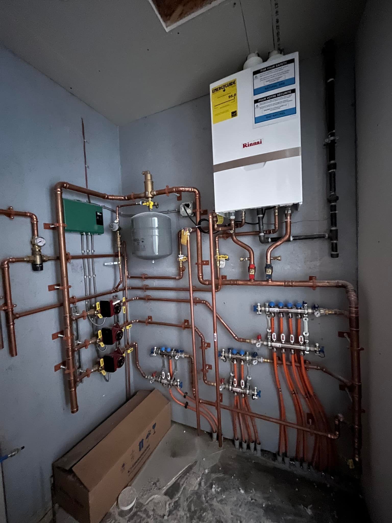 A room with a lot of pipes and a box on the floor