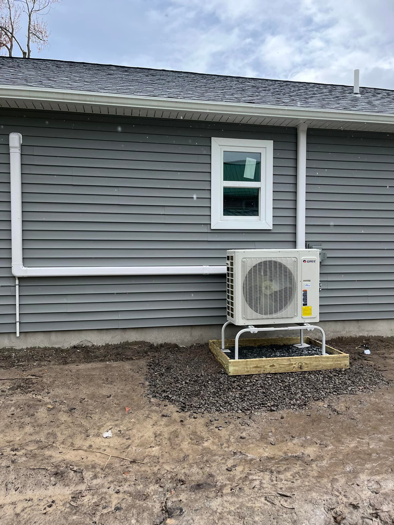 A house with a window and an air conditioner on the side of it.