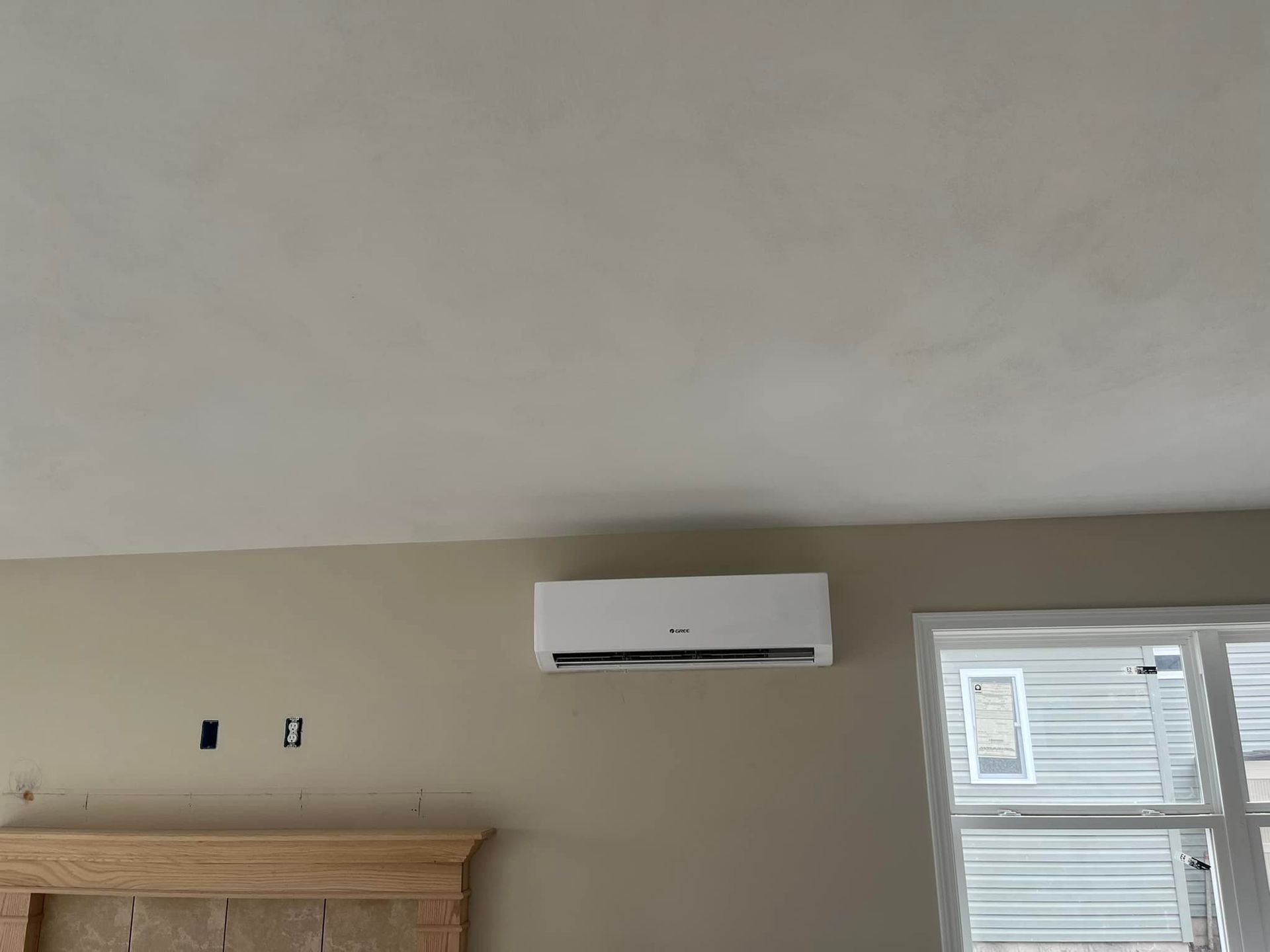 A room with a fireplace and a wall mounted air conditioner.