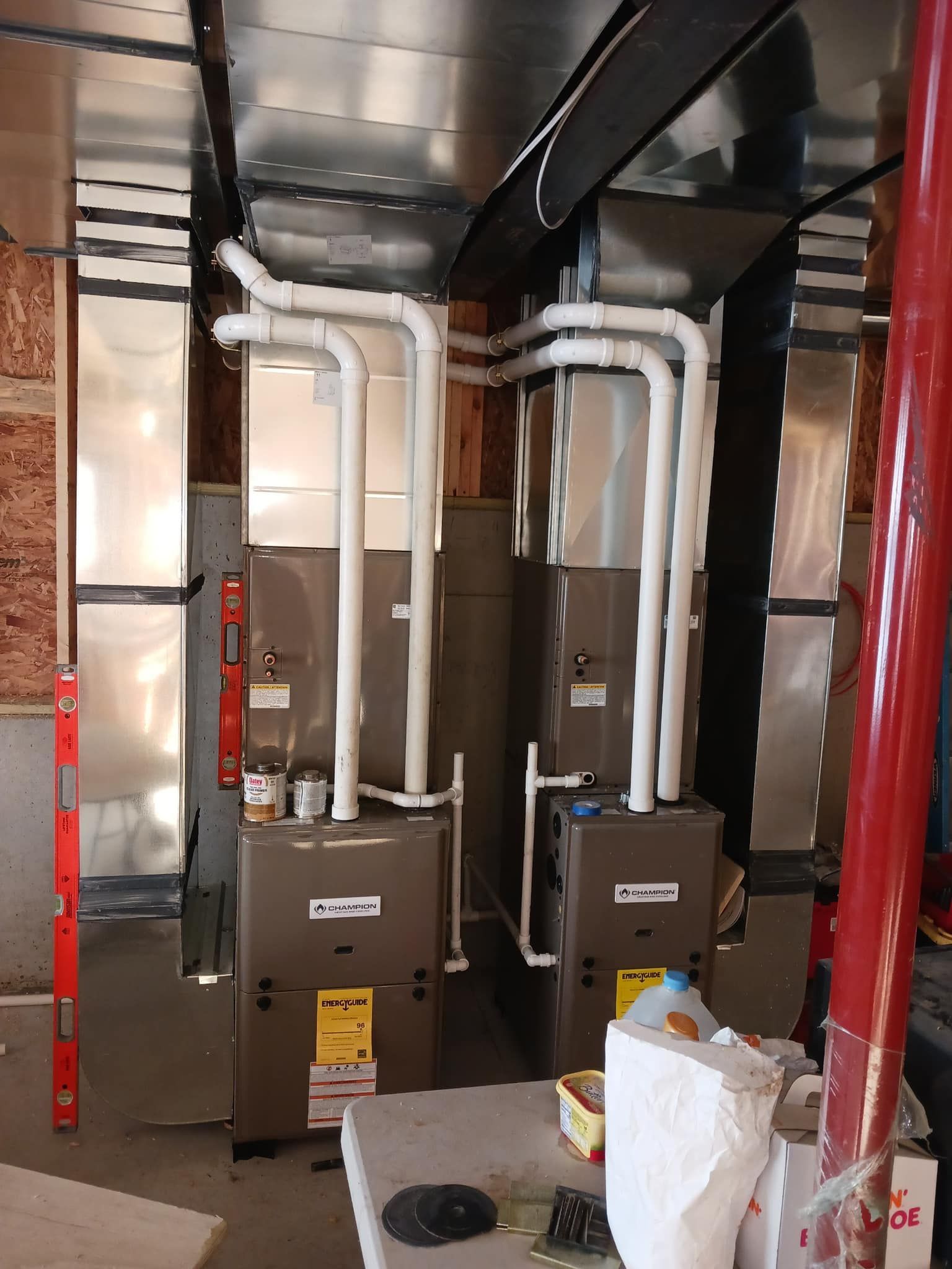 Two air conditioners are sitting next to each other in a room.