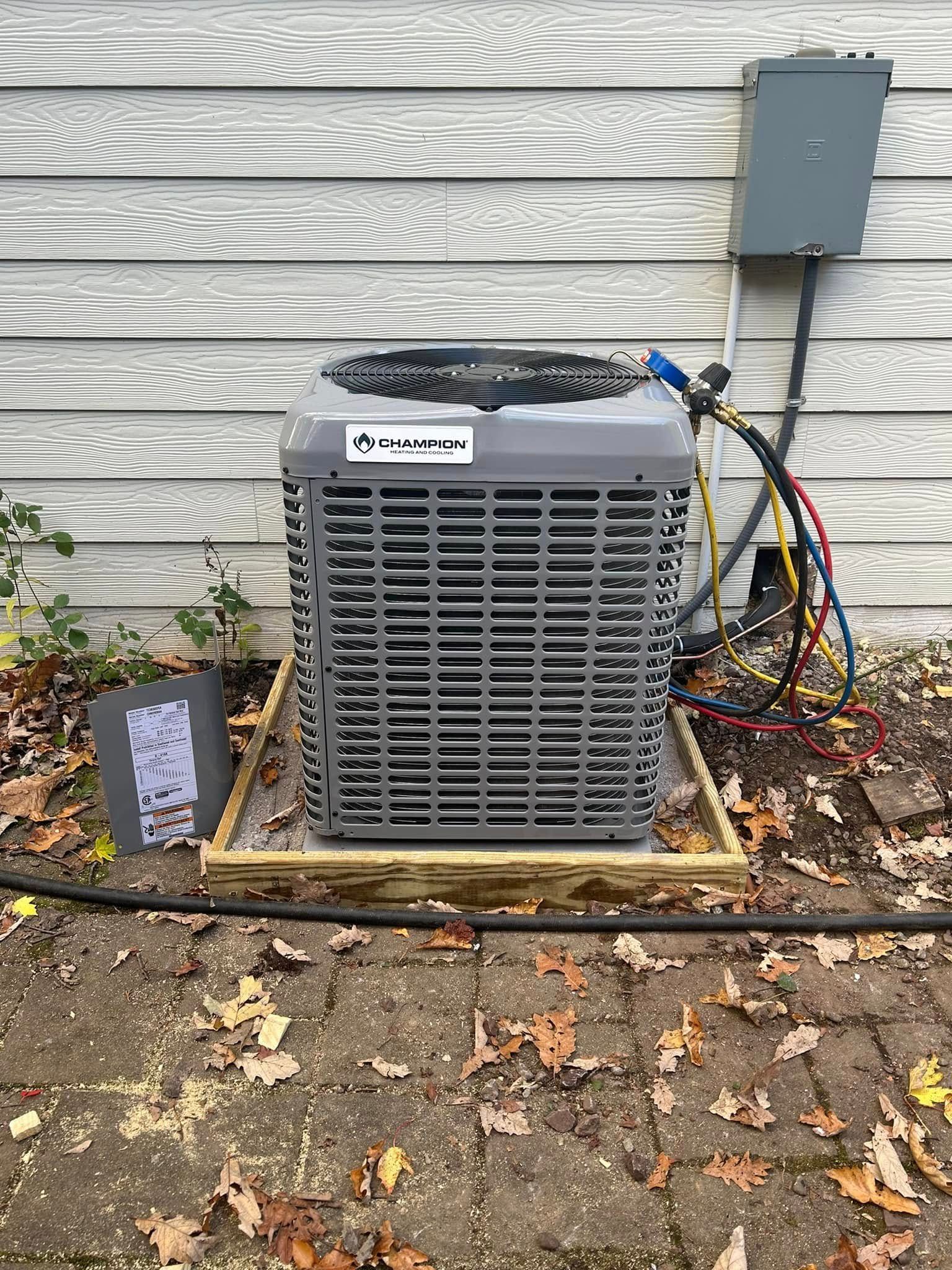 An air conditioner is sitting on top of a wooden box on the side of a house.