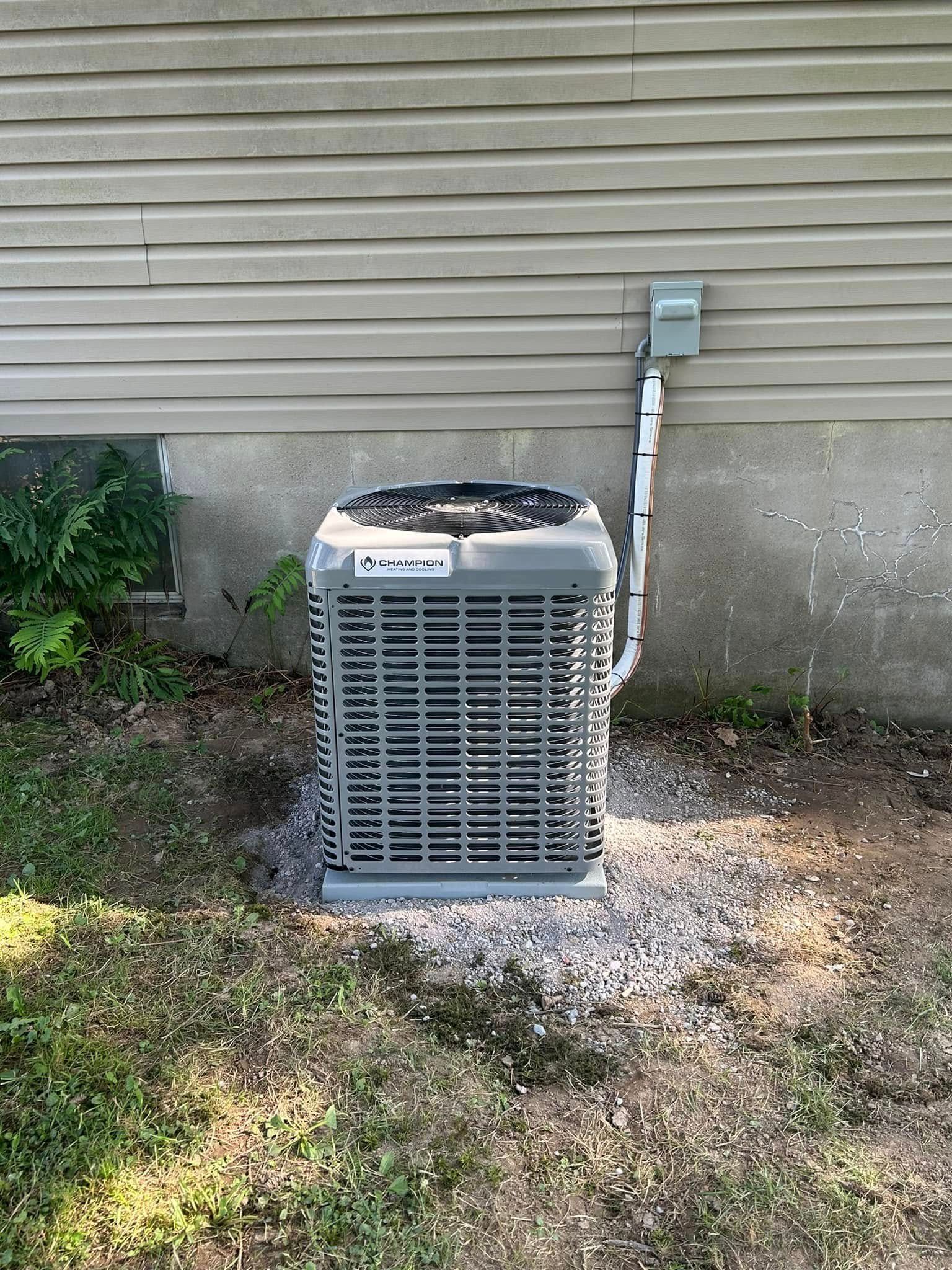 An air conditioner is sitting on the side of a house.