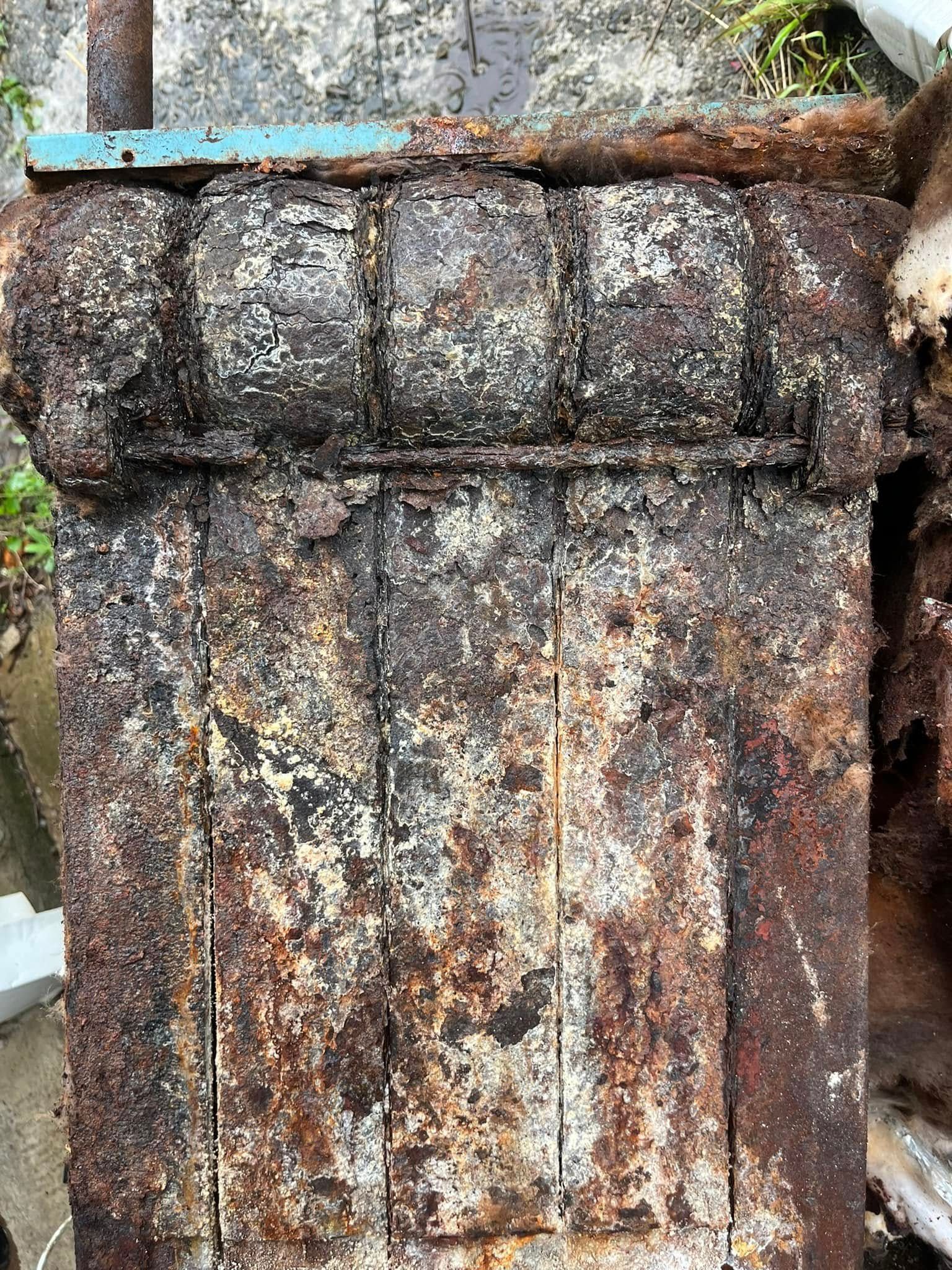 A close up of a rusty piece of metal on a rock.