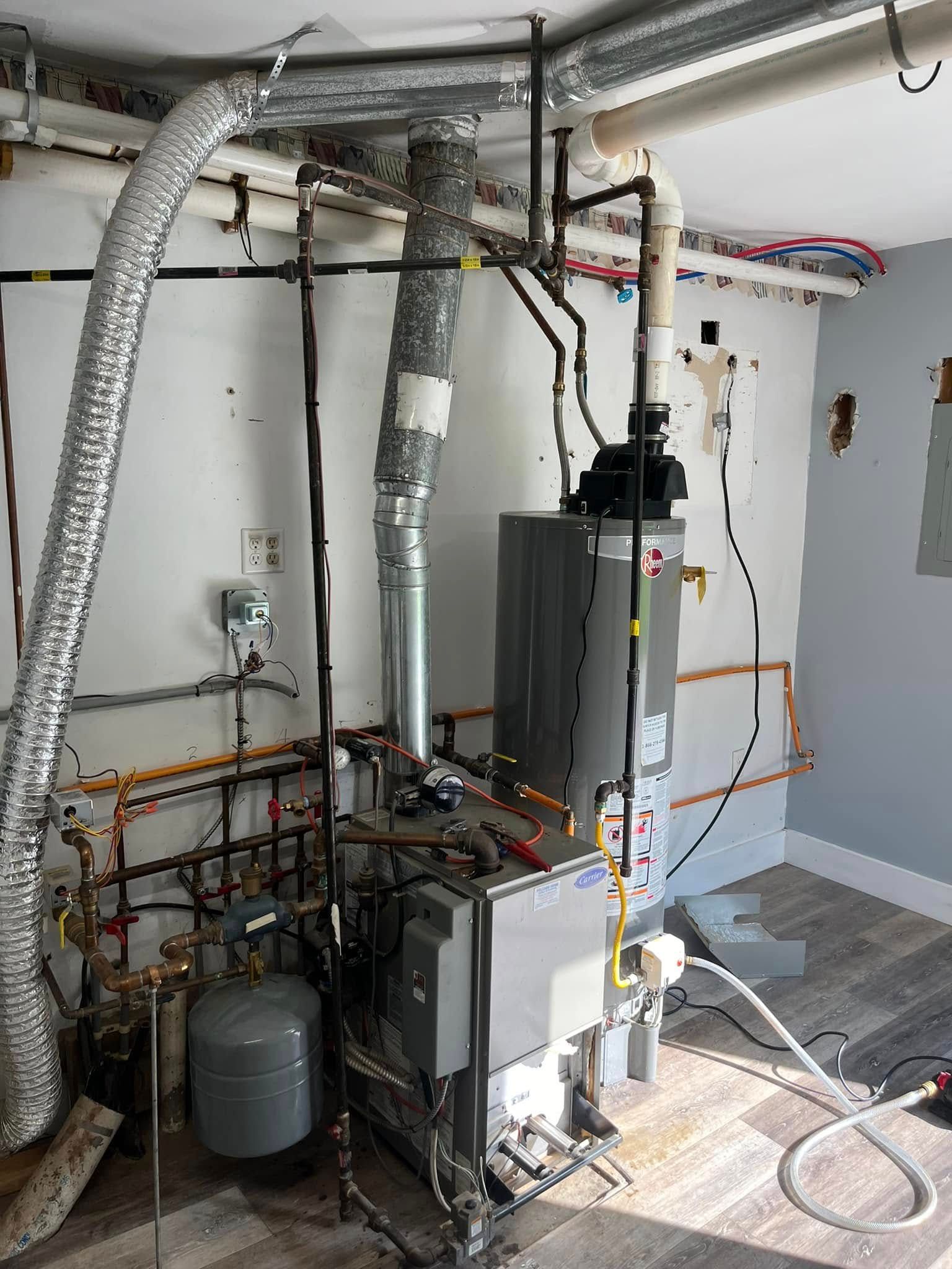 A room with a lot of pipes and a water heater.