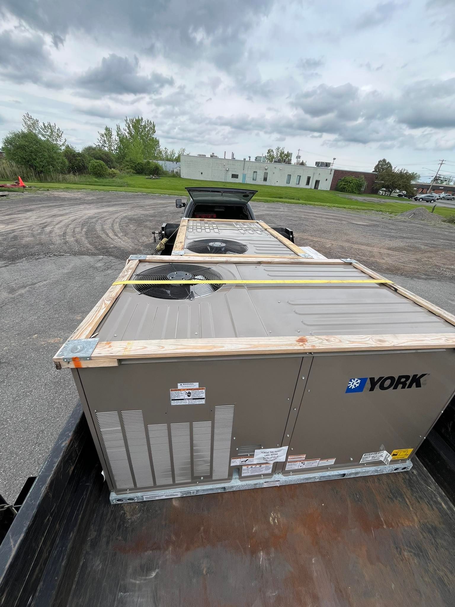 A bunch of air conditioners are sitting in the back of a truck.