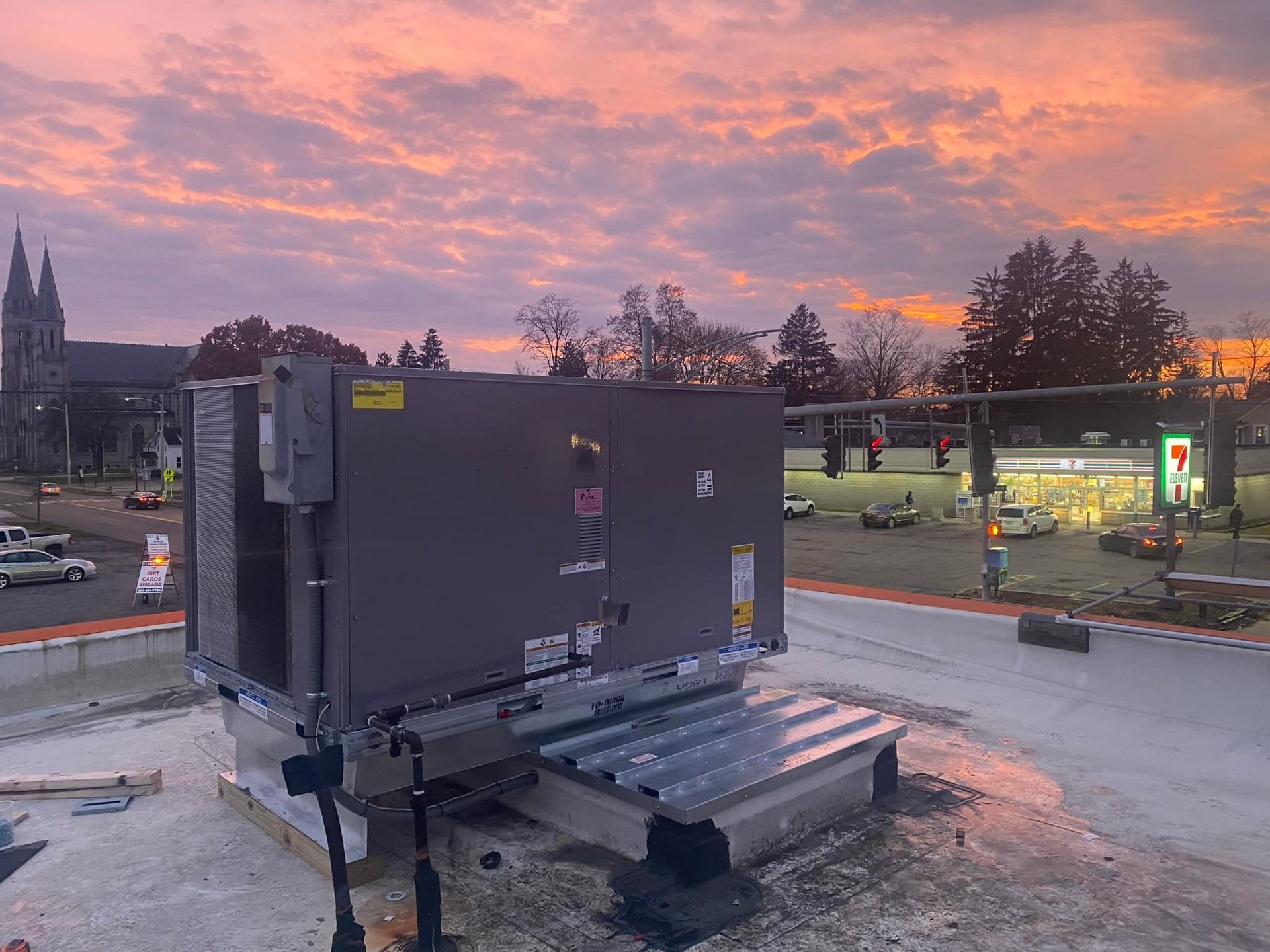A large box is sitting on top of a roof with a sunset in the background.