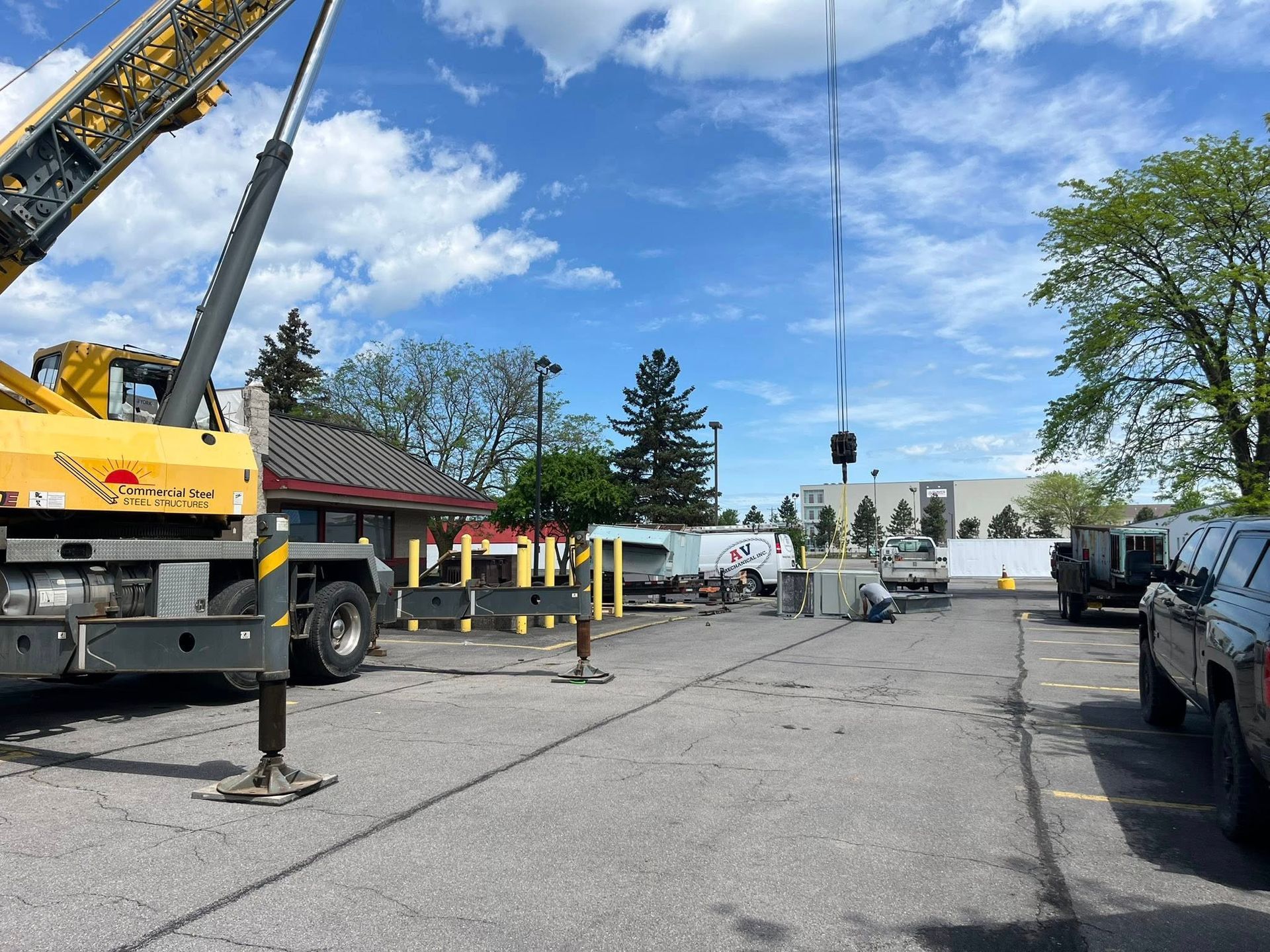 A large yellow crane is parked in a parking lot