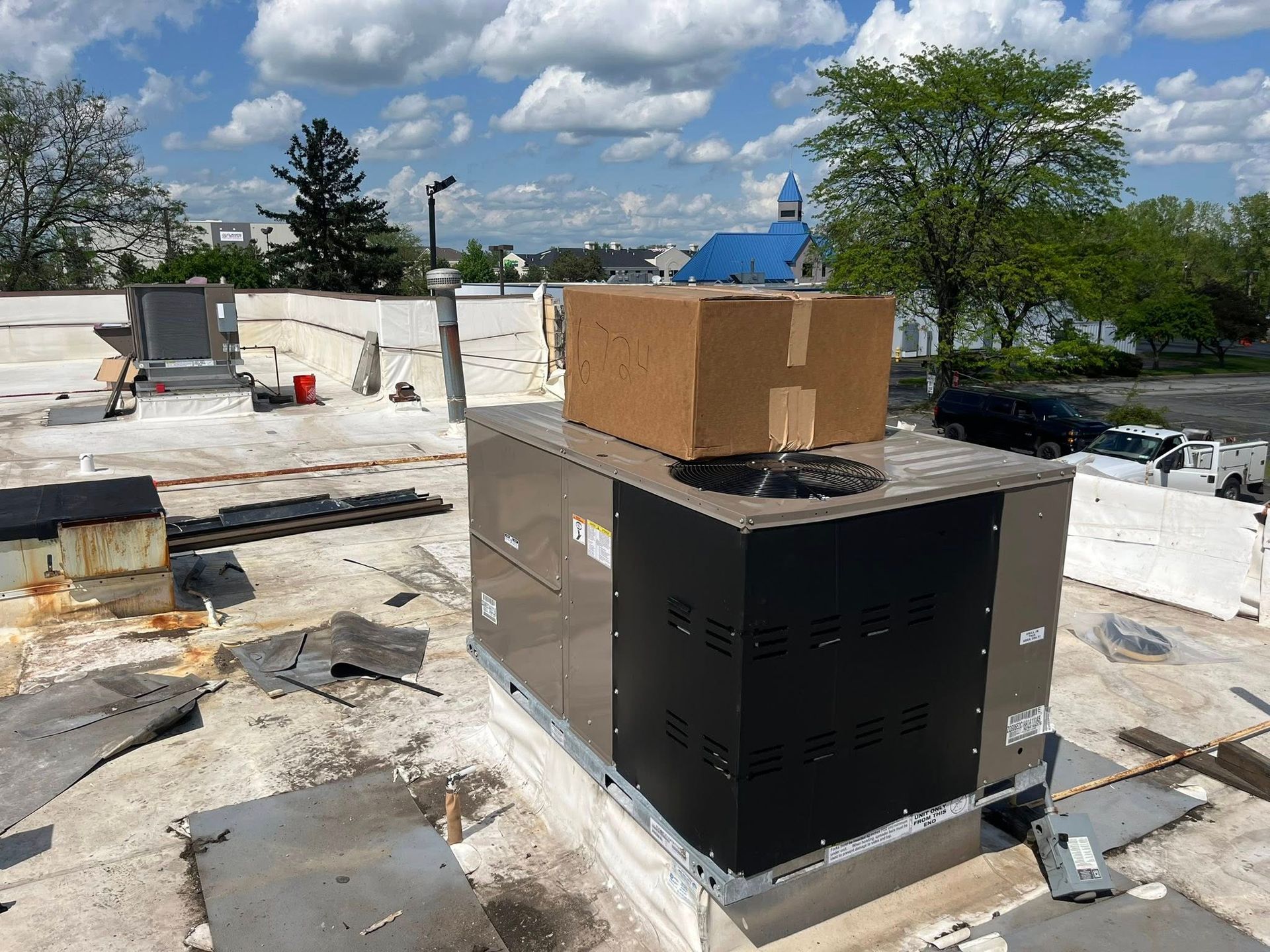 A box is sitting on top of an air conditioner on a roof.