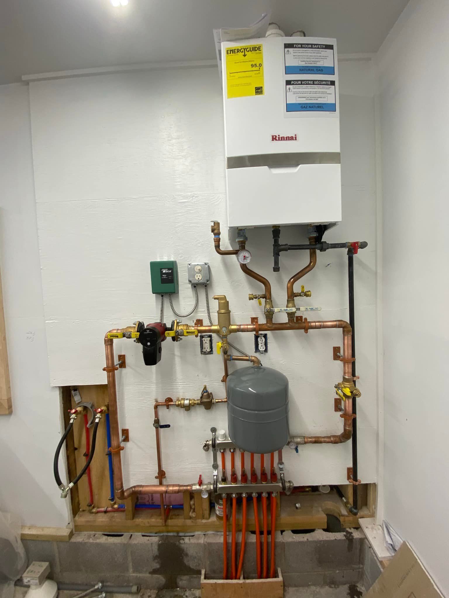 A room with a boiler and pipes on the wall.