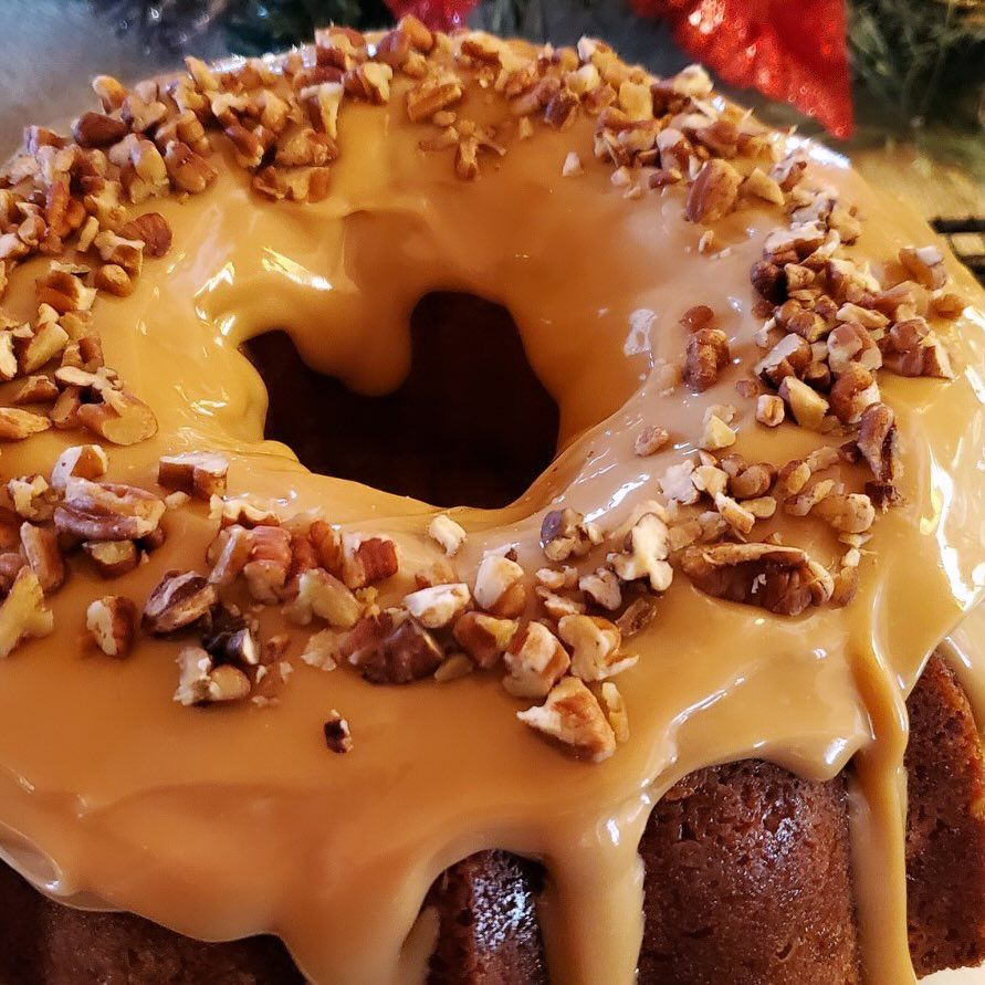 A bundt cake with caramel icing and pecans on top