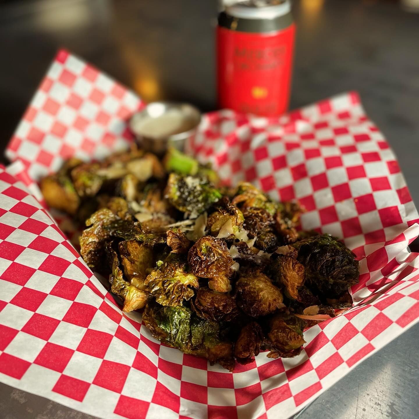 A close up of a plate of food on a checkered paper on a table.