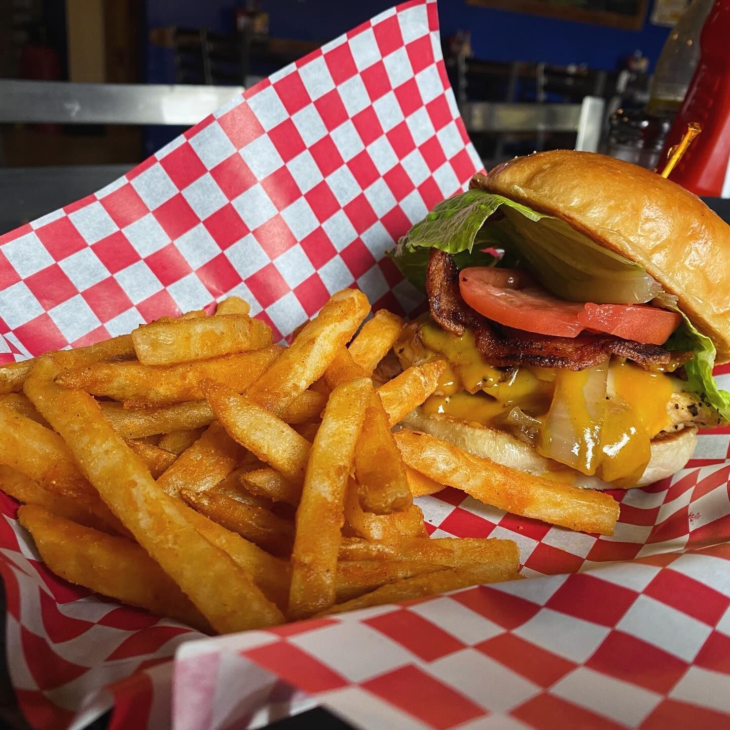 A hamburger and french fries on a checkered paper
