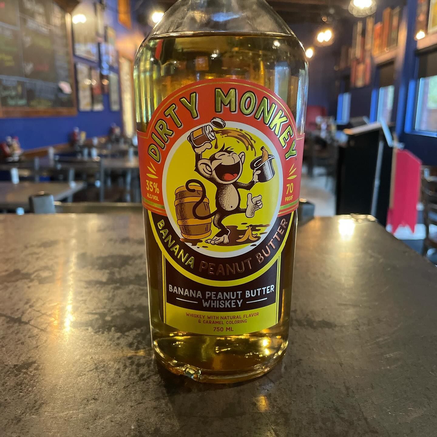 A bottle of dirty monkey banana peanut butter whiskey on a table