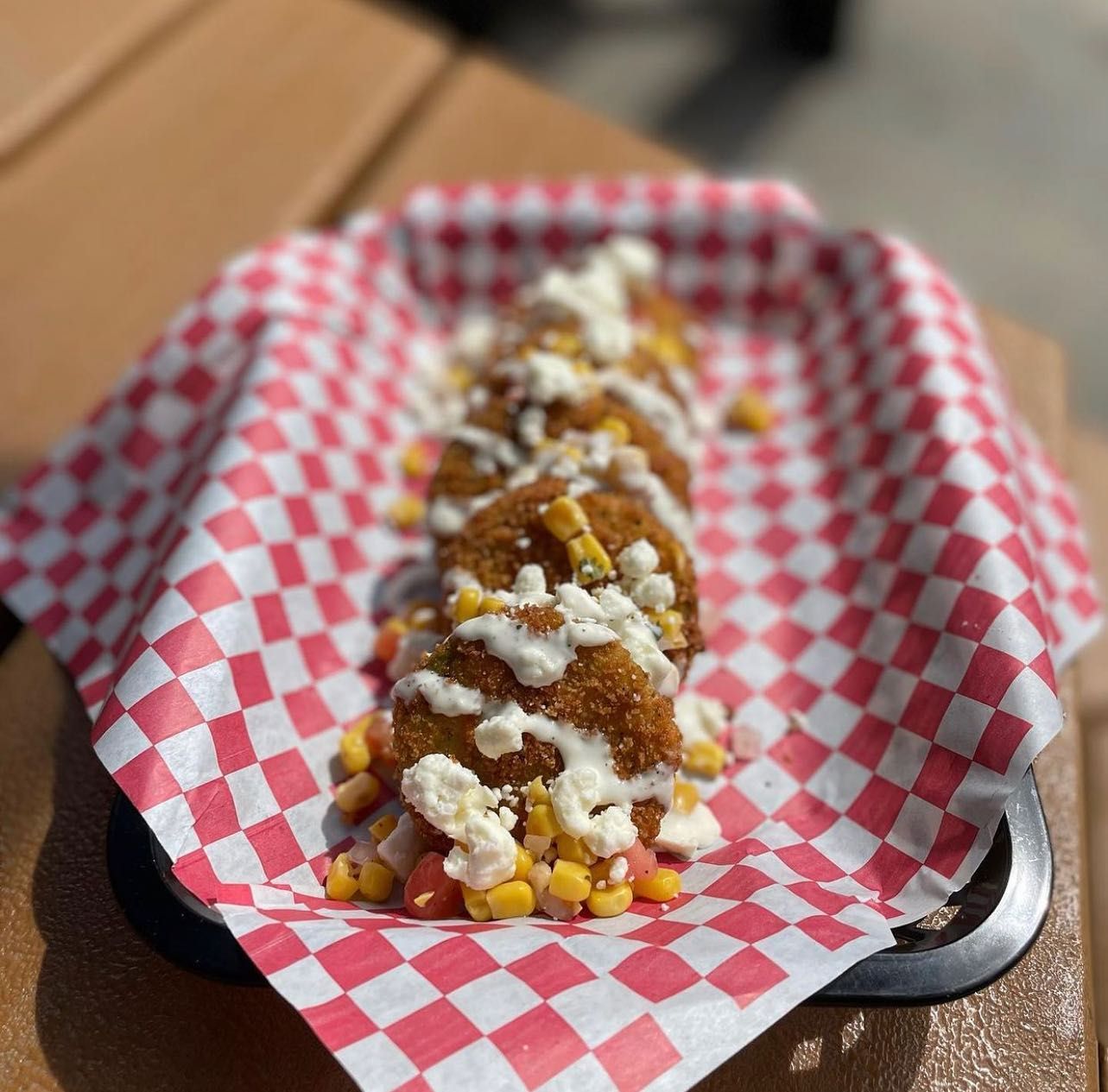 A tray of food on a checkered paper on a table