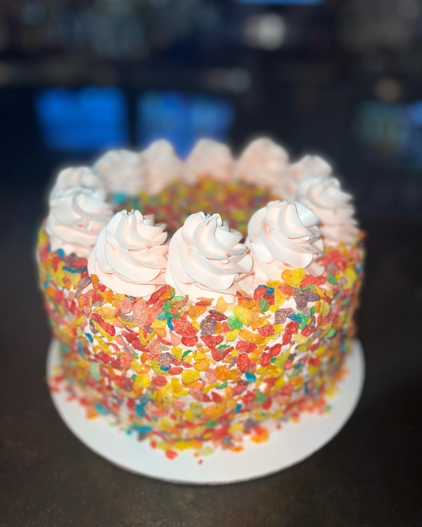 A cake with sprinkles and whipped cream on top of it.