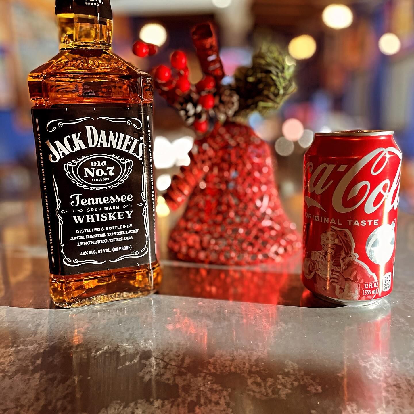 A bottle of jack daniels next to a can of coca cola