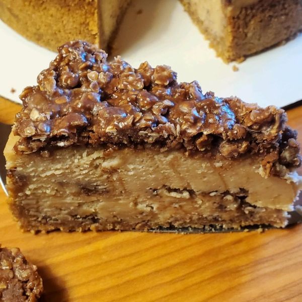 A slice of chocolate cheesecake is sitting on a wooden table