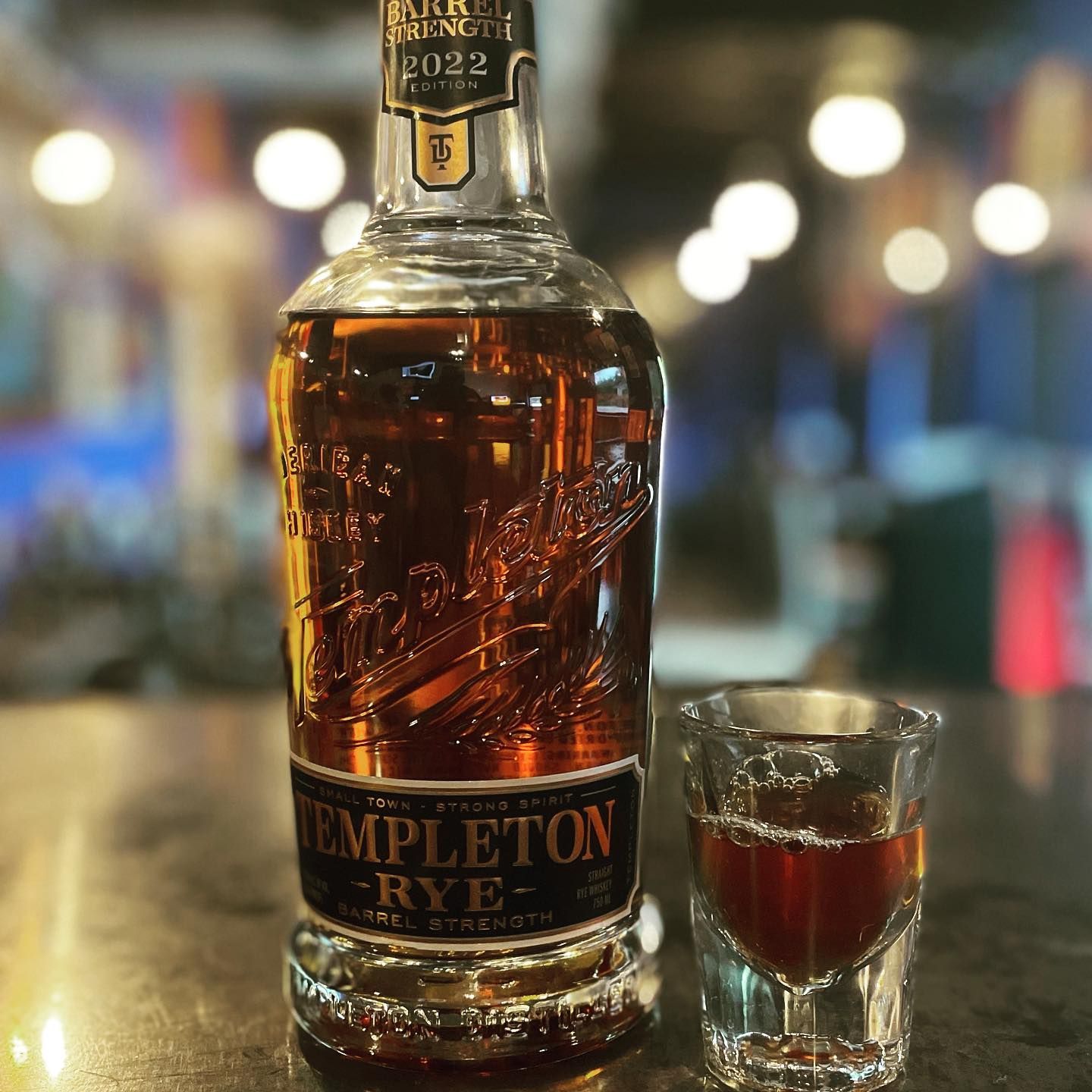A bottle of templeton rye next to a shot glass