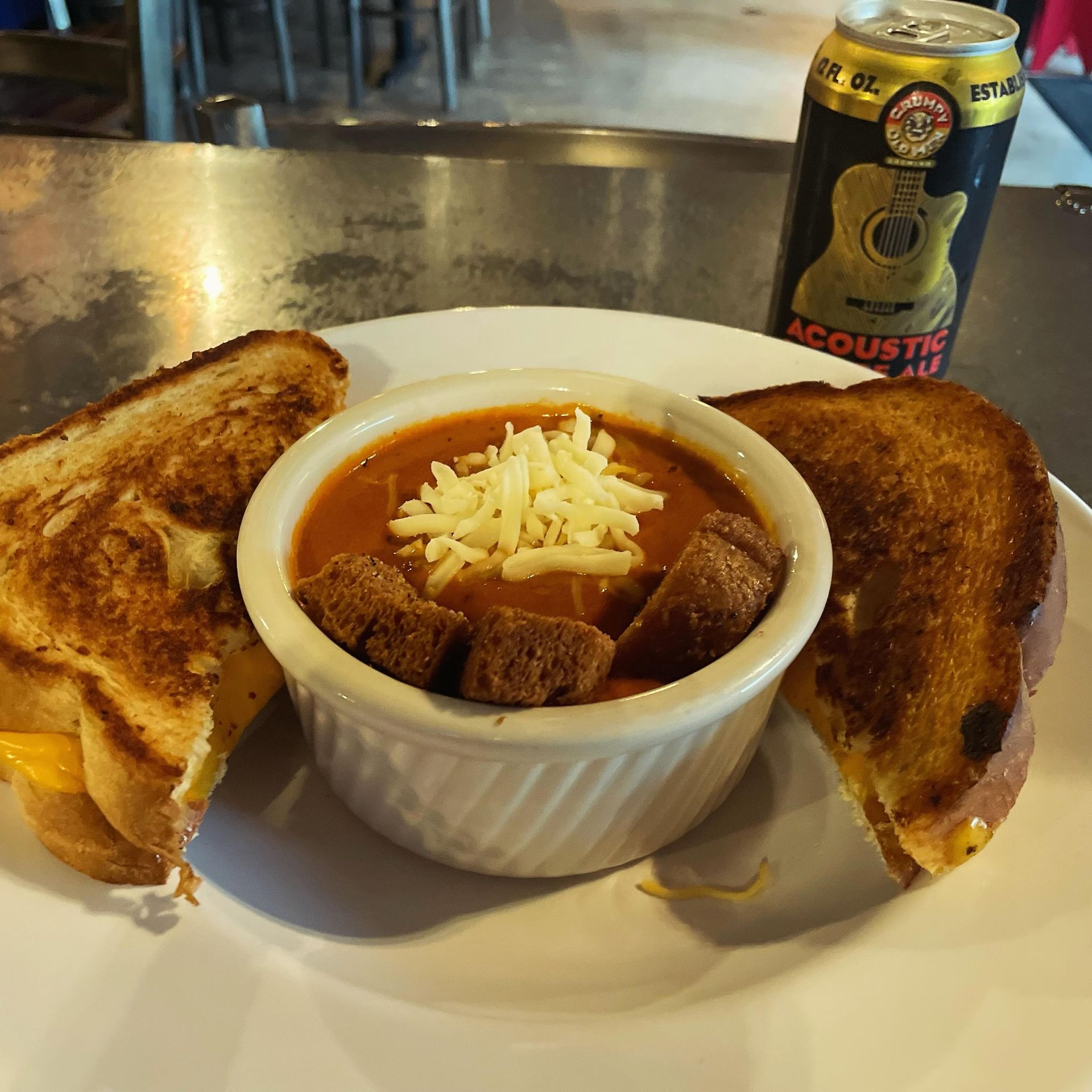A plate of food with a can of acoustic ale in the background