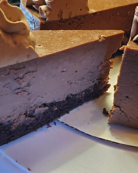 Three slices of chocolate cheesecake on a white plate