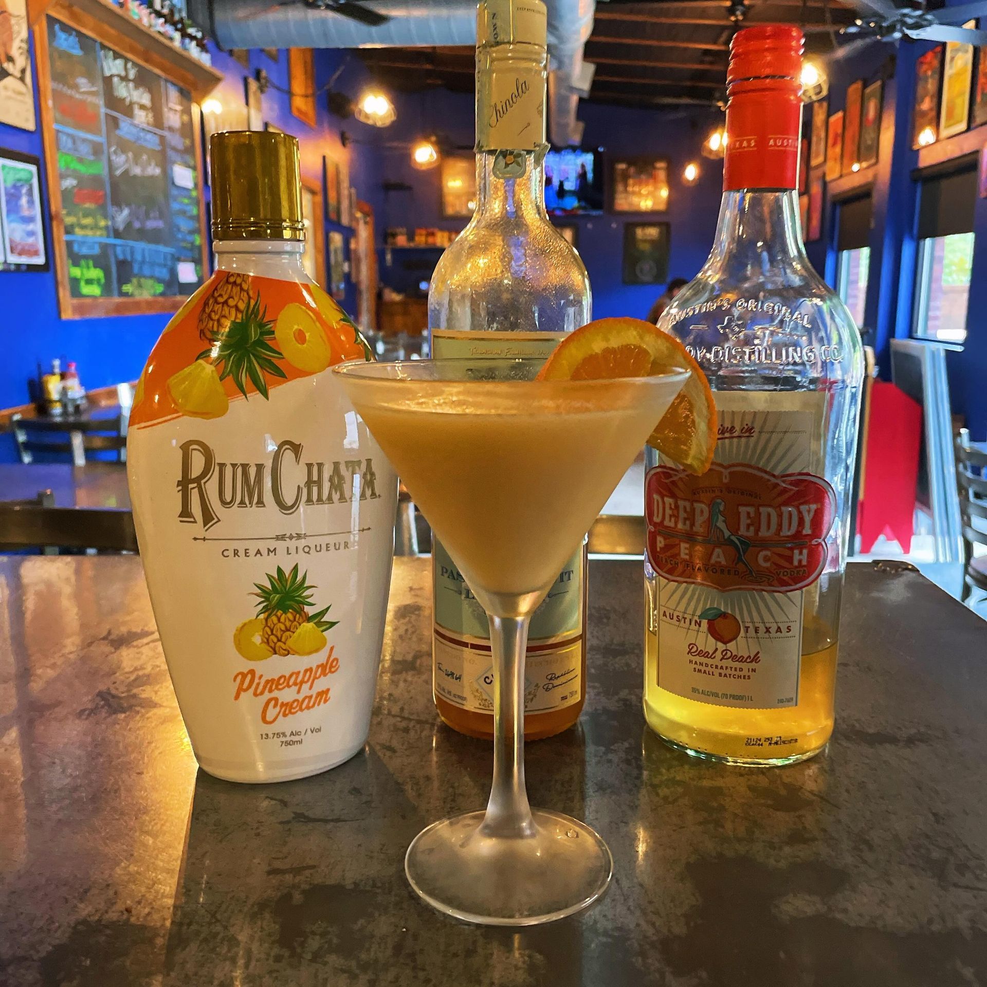 A bottle of rum chata is next to a martini glass