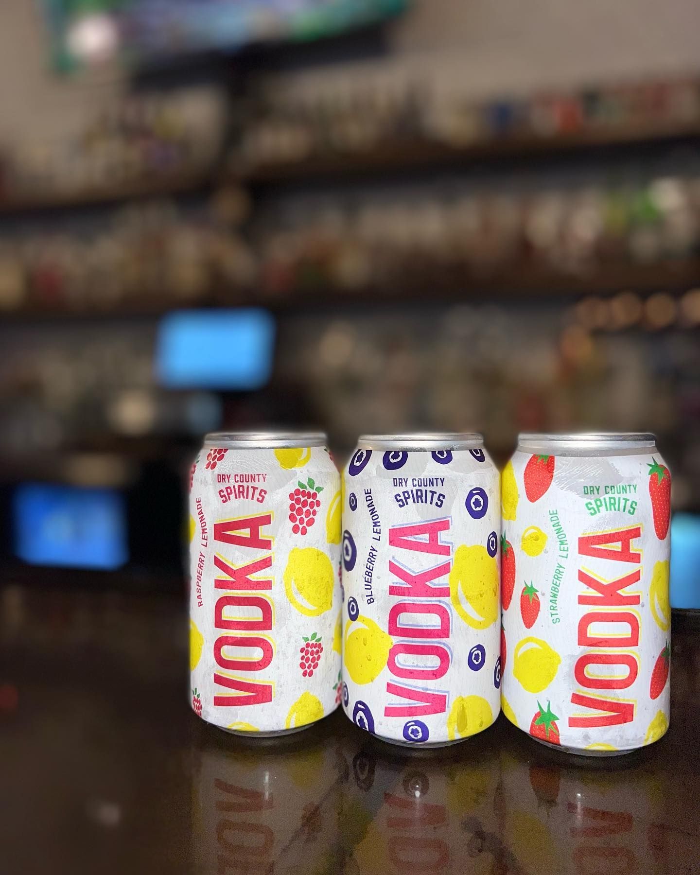 Three cans of vodka are sitting on a table.