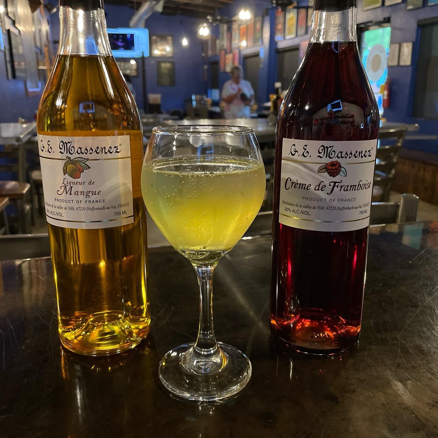 Two bottles of wine and a glass of wine on a table