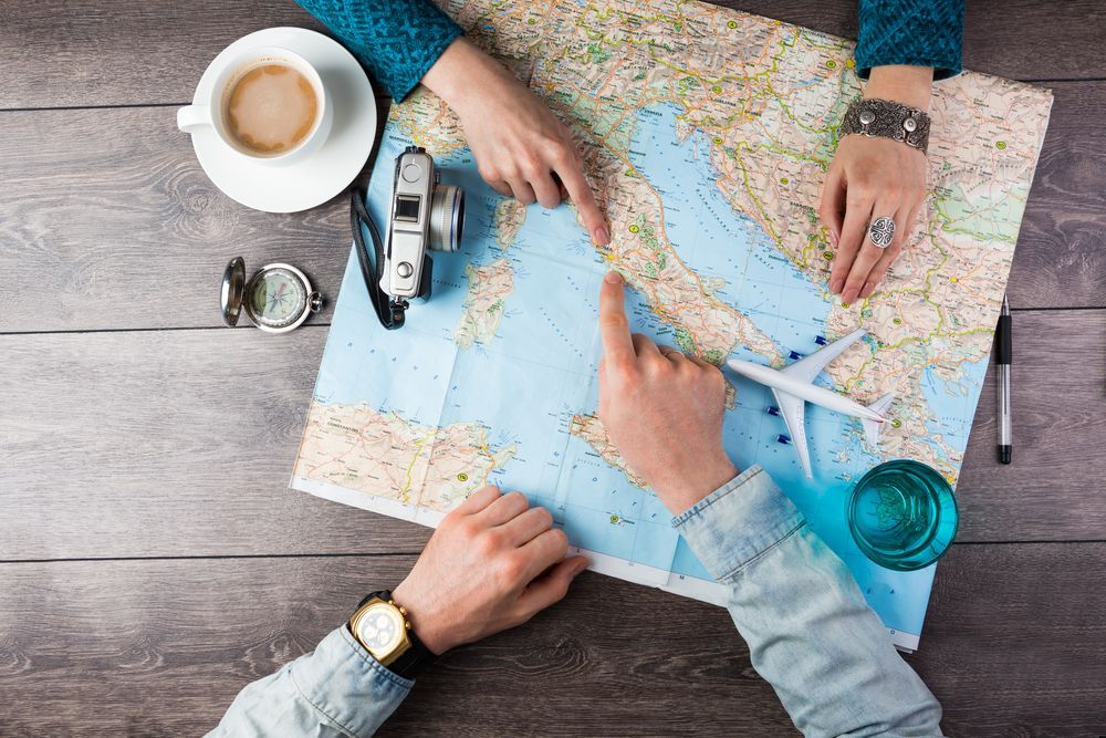 A man and a woman are sitting at a table looking at a map.