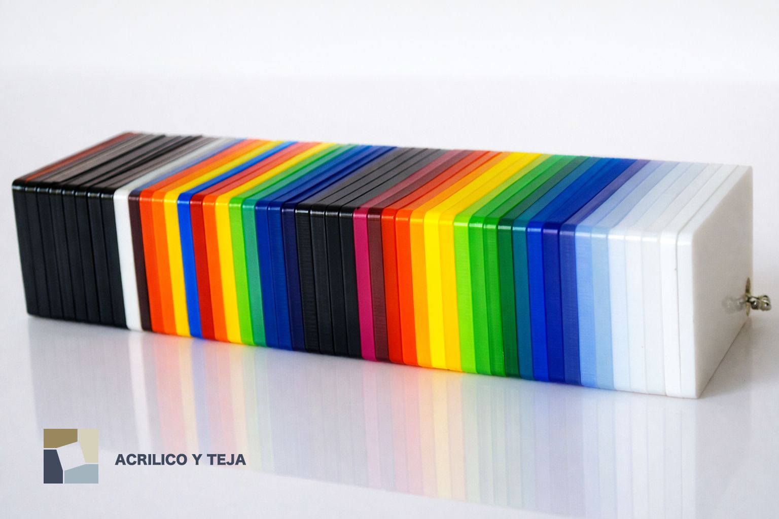 Una pila de láminas acrílicas rectangulares codificadas por colores, dispuestas en un espectro que va del negro al blanco.