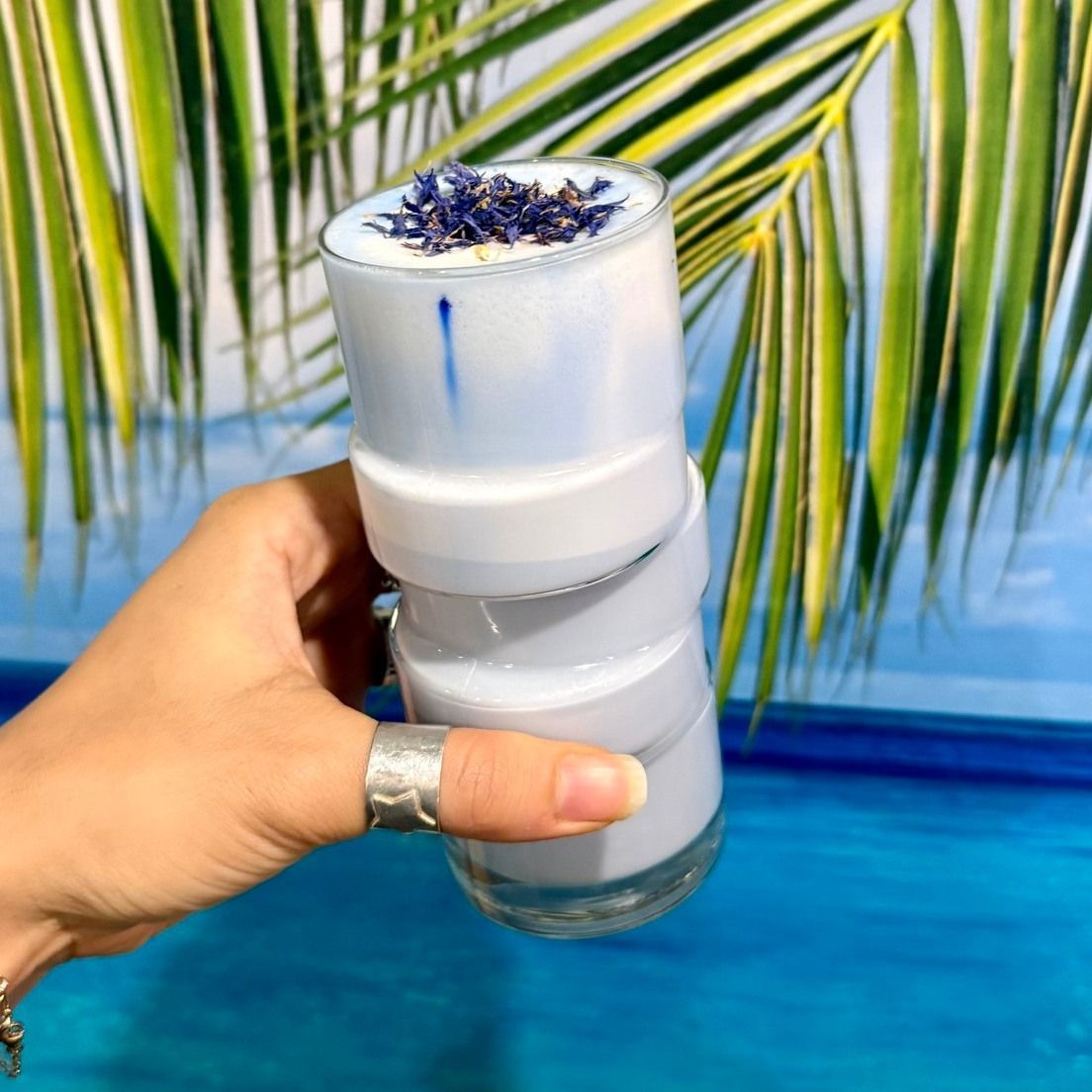 Hand Holding a Glass With Blue Drink, Topped — Relax in Paradise in Yeppoon, QLD
