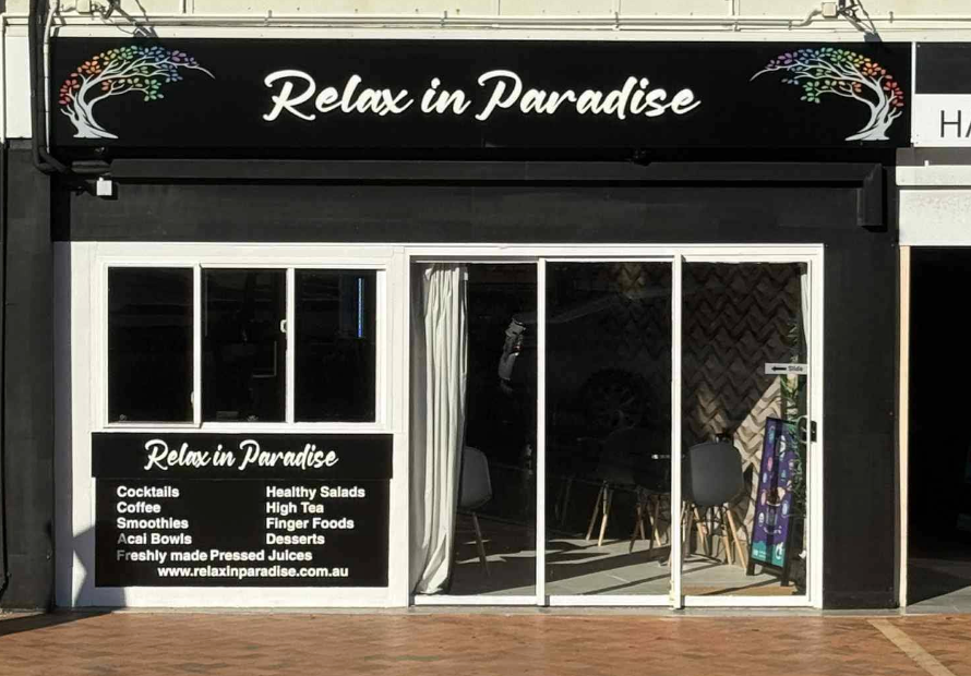 Cozy cafe interior with seating, string lights, and blue wall art.— Relax in Paradise in Yeppoon, QLD