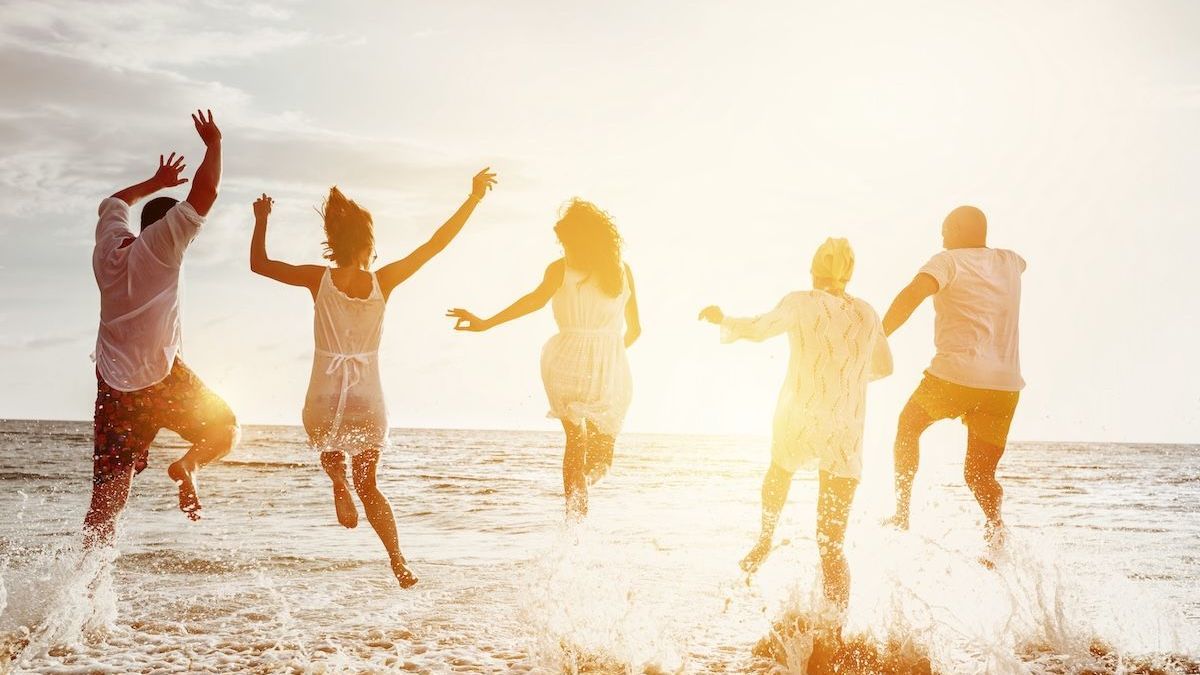 Group of friends jumping on the beach