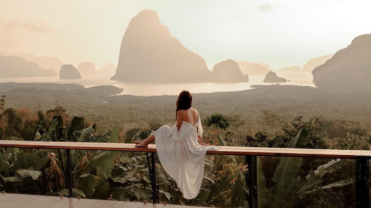 Lady overlooking nature from hotel balcony
