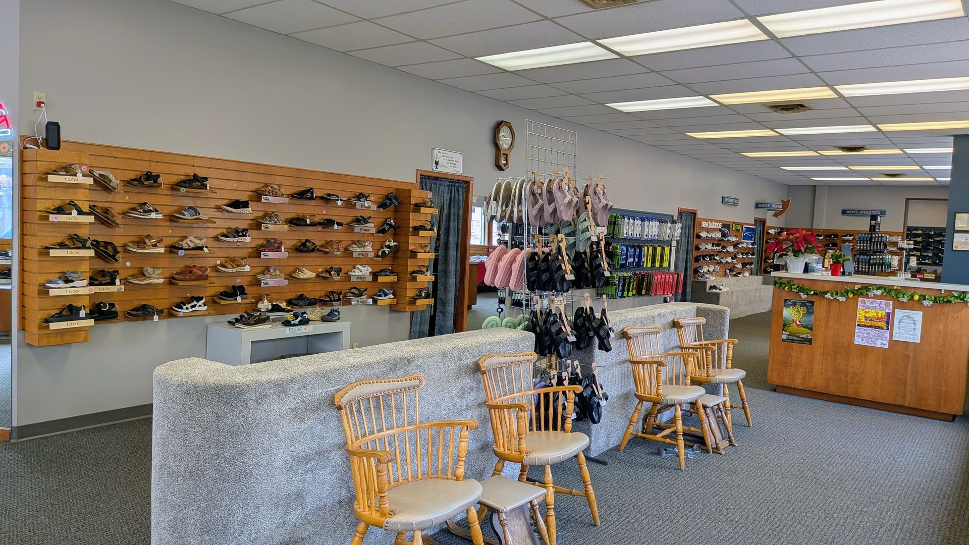 Eyewear shop interior with sunglasses display wall, chairs, and a counter with accessories