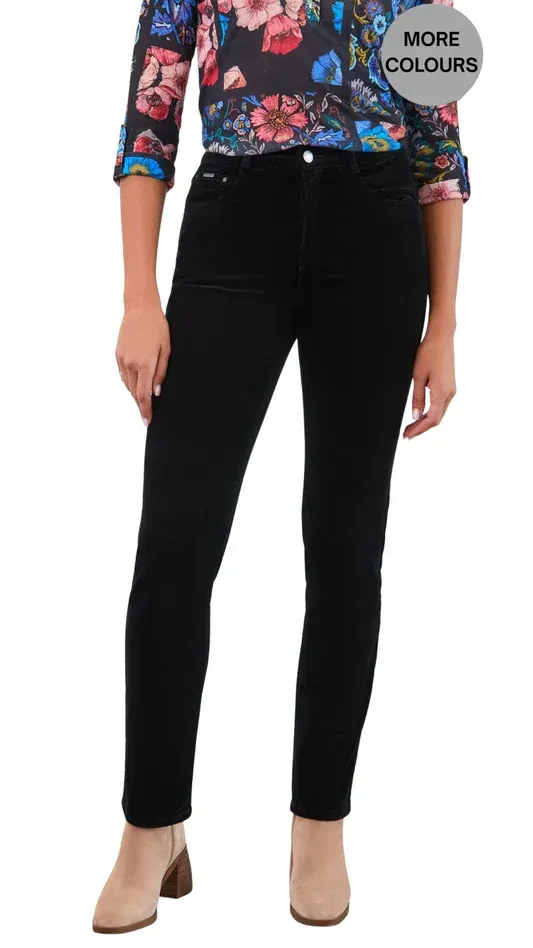 A person wearing a floral long-sleeved shirt and black corduroy pants with beige block-heel ankle boots.