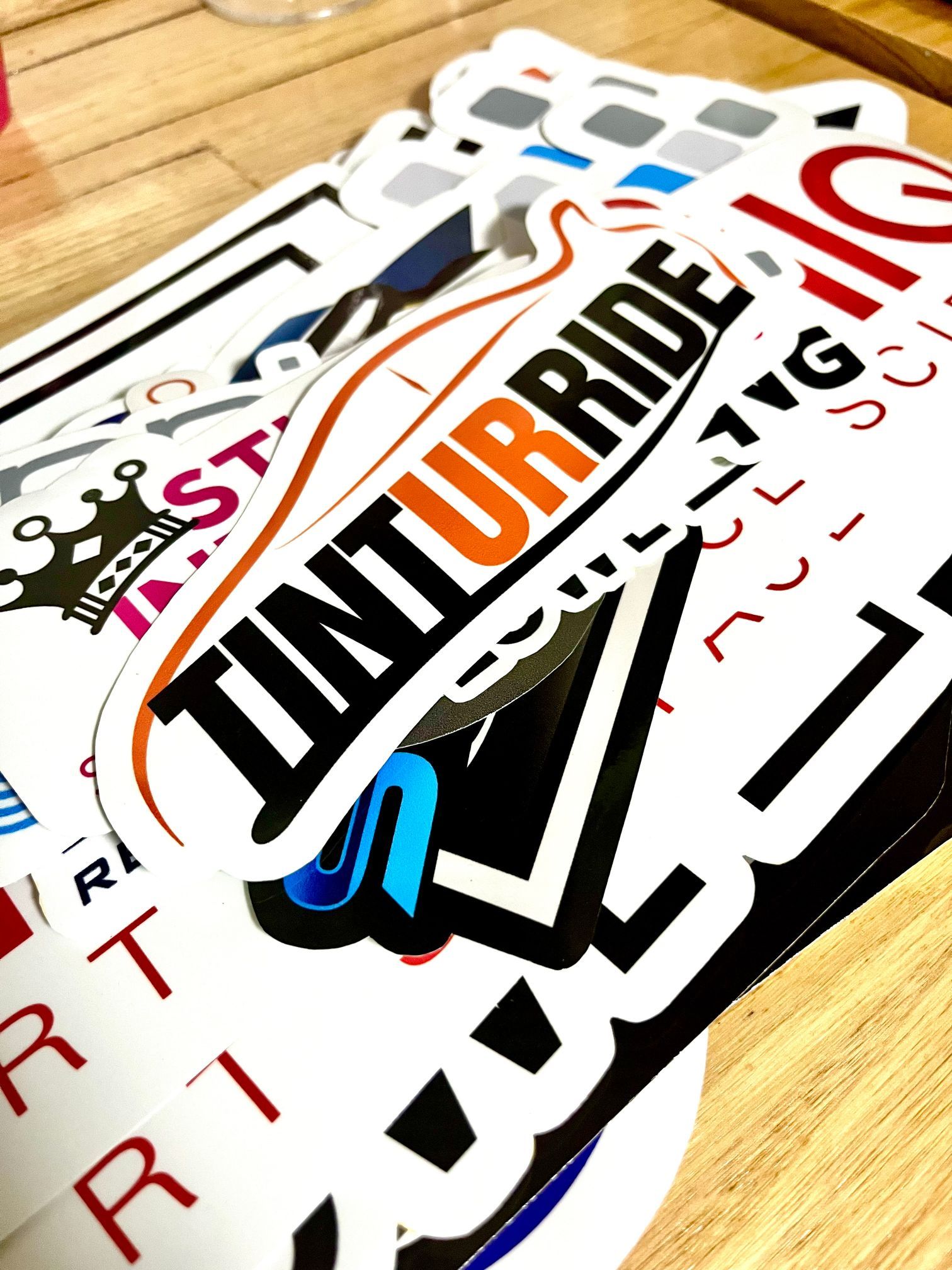 Pile of Colourful Stickers on A Wooden Surface — Stuckup Industries in Morisset, NSW