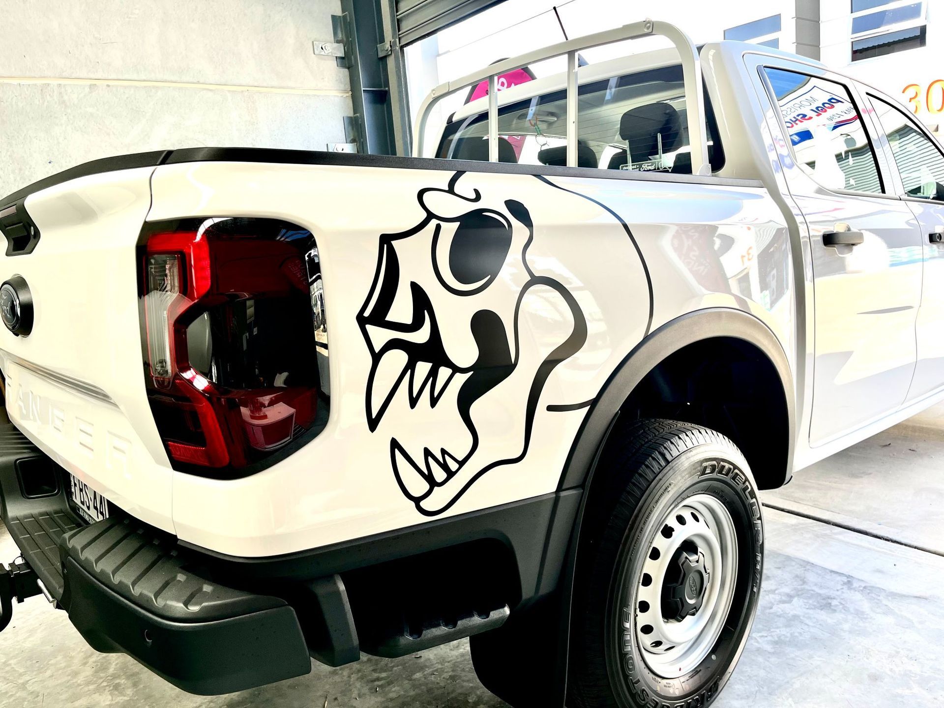 White Pickup Truck with A Black Skull Sticker on The Side Panel — Stuckup Industries in Morisset, NSW