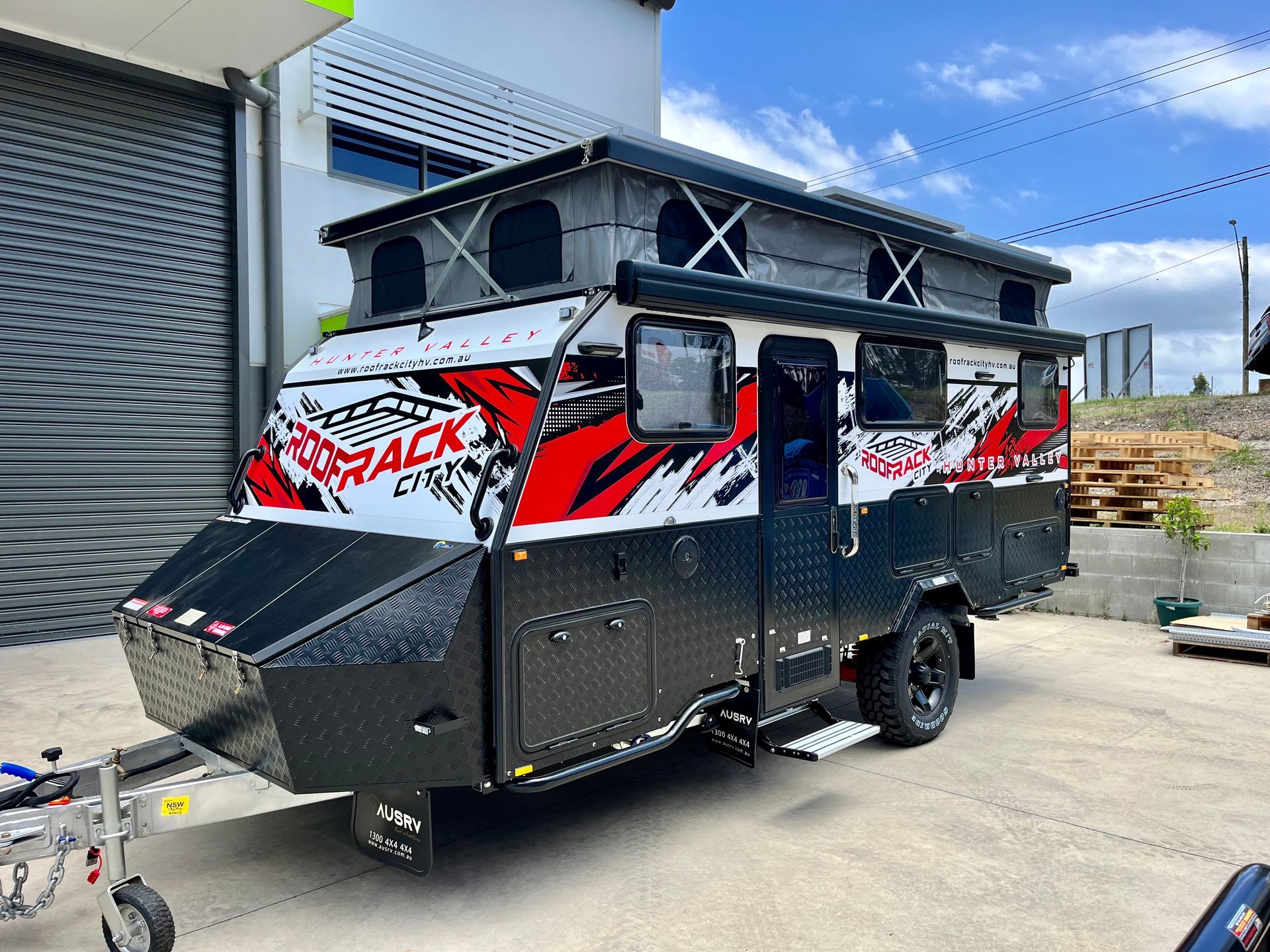 Black and red off-road camper trailer parked outside a building — Stuckup Industries in Morisset, NSW