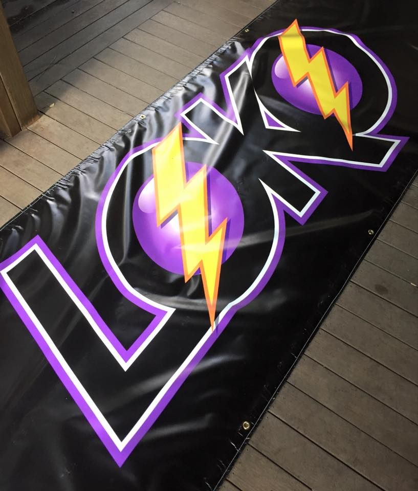Banner with Purple Circles with Yellow Lightning Bolts, Outlined in White, on Black — Stuckup Industries in Morisset, NSW