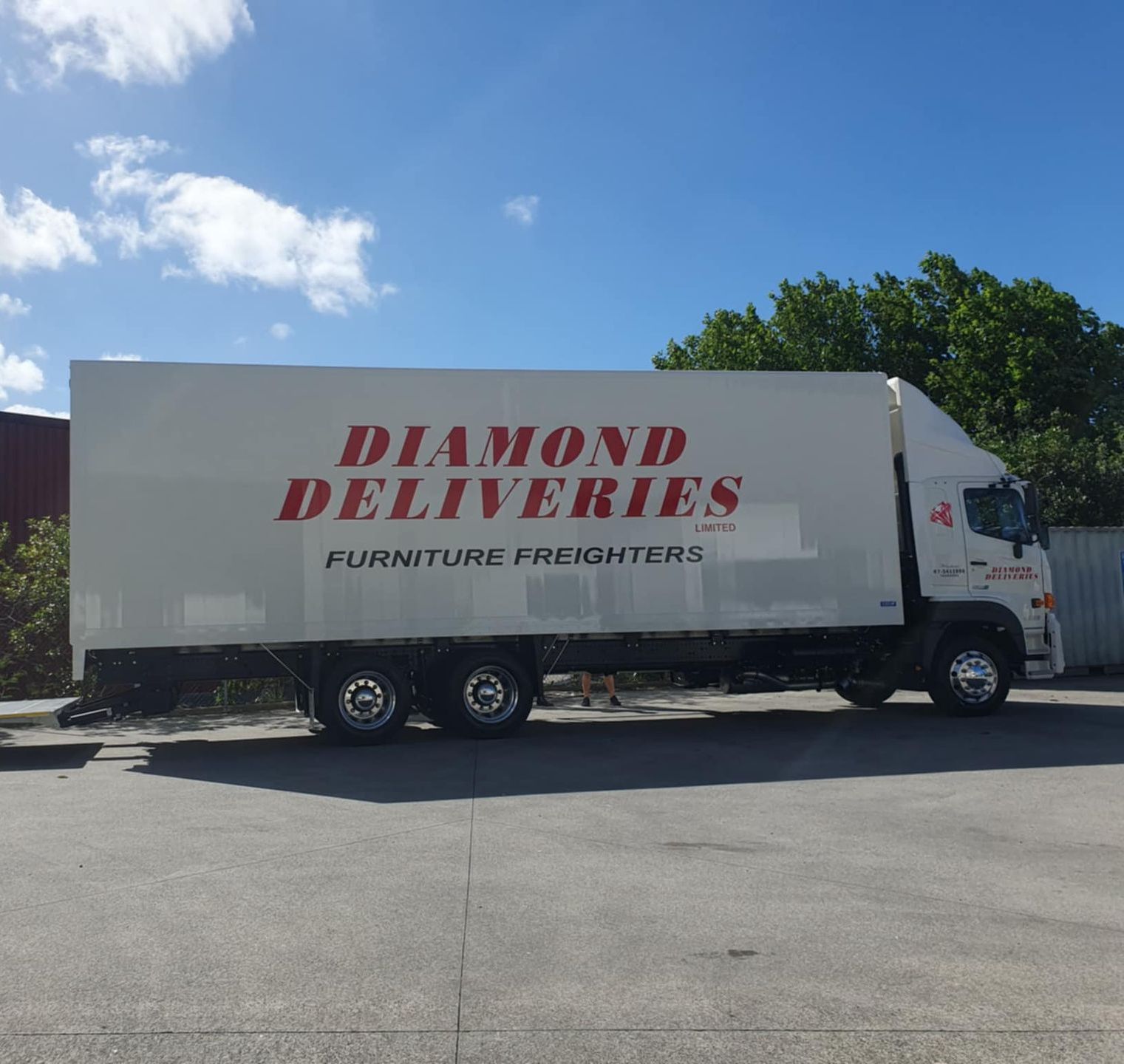 A forklift is loading a shipping container in a warehouse.