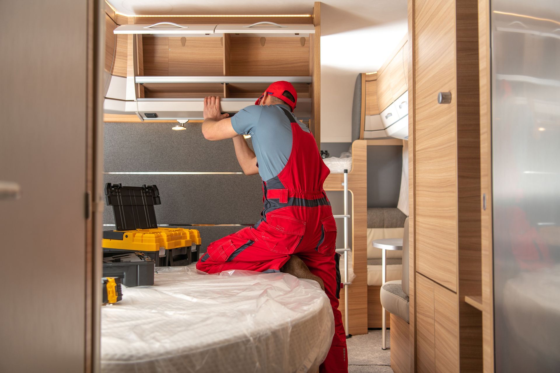 Technician repairing interior cabinets in RV. Technician repairing interior cabinets in RV.